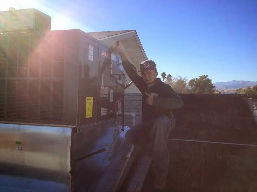HVAC technician performing AC Tune-Up on a rooftop unit in Cullman